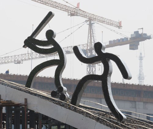 Sports-themed sculptures are installed on a steel structure at Beijing's Tian'anmen Square.