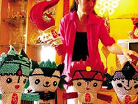 The picture published on Tuesday, July 22, 2008 shows disabled artist Cai Jianhua and Olympic-themed handicrafts. 