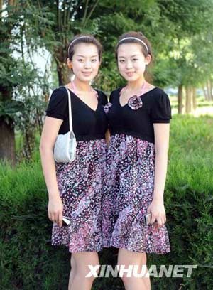 The 19-year-old twin sisters, Li Xiaoye(left) and Li Ziye pose for photographers at the campus of Beijing Changping Vocational School. 337 volunteres gathered here to be trained for serving Olympic rewarding ceremony.