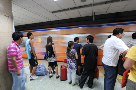 Passengers wait on the platform at a subway station in Beijing, capital of China, July 22, 2008.