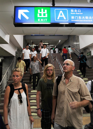 Foreign visitors walk into Qianmen subway station in Beijing, capital of China, July 22, 2008.