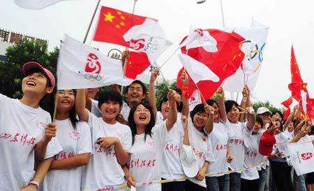 People cheer for the 2008 Beijing Olympic Games torch relay in Tai'an, a city of east China's Shandong Province, on July 22, 2008.