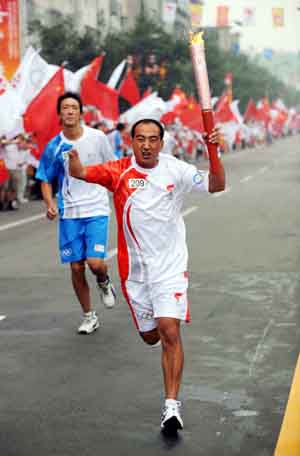  Handicapped torchbearer Cao Shenggang runs with the torch during the 2008 Beijing Olympic Games torch relay in Tai'an, a city of east China's Shandong Province, on July 22, 2008.