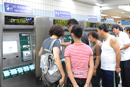 Passengers buy tickets at an automatic ticket machine at Tian'anmen east subway station in Beijing, capital of China, July 22, 2008.