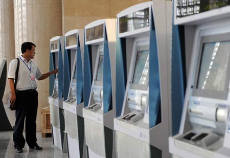 A staff member tries the auto-ticket selling machine in the Tianjin Railway Station in north China's Tianjin Municipality, July 21, 2008. Built in 1888, the Tianjin Railway Station went through an expansion project since January 2007 for the upcoming Beijing Olympic Games. The new Tianjin Railway Station will be put into use on Aug. 1, 2008, the same day as the Beijing-Tianjin express railway opens to the public. 