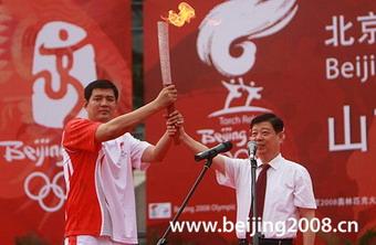 The first torchbearer Gong Xiaobin receives the torch during the Torch Relay in Jinan, Shandong province, on July 23.
