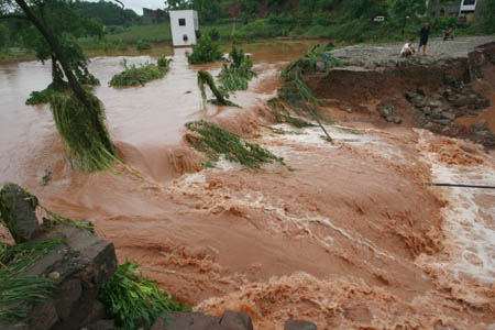 A bridge is destroyed by the flood in Daying County of Suining City, southwest China's Sichuan Province, July 21, 2008. A heavy rainstorm hit the city on Monday and Daying County was seriously flooded. Armed Police soldiers and officers stationed in Suining and the local residents have thrown themselves into the fight against the floods in the county. (Xinhua/Zhong Min)