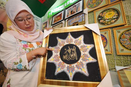 An exhibitor of Hui ethnic group shows a wire inlay painting during the first Ningxia Culture Travel Products Show in Yinchuan, capital of northwest China's Ningxia Hui Autonomous Region, July 23, 2008.