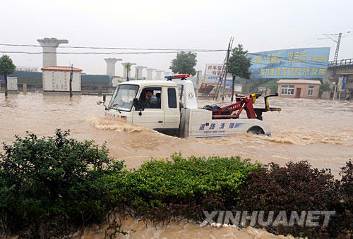 7月24日，一辆道路清障车在襄樊积水的道路上行驶。从7月22日凌晨起，湖北襄樊全市遭受特大暴雨袭击。截至24日18时，全市有81个乡镇108万多人受灾，转移安置受灾群众8万多人。目前，部分乡镇仍未恢复通讯，灾情在进一步扩大。 新华社记者 余国庆 摄