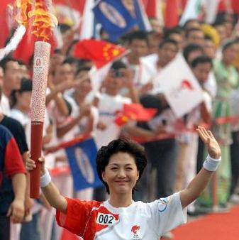 Hai Xia, a news anchor from the China Central Television (CCTV) carries the Olympic torch in Zhengzhou, Henan Province July 25.
