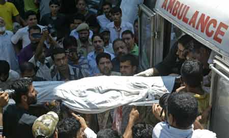 Kashmiri paramedics carry the body of a person killed in a grenade explosion in Srinagar July 24, 2008. A child and a woman were killed and more than a dozen civilians wounded on Thursday when suspected Muslim separatist militants lobbed a grenade at a crowded bus terminal in Indian Kashmir's main city, police said. 