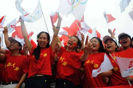 Spectators greet the torch during the 2008 Beijing Olympic Games torch relay in Kaifeng, central China's Henan Province, July 26, 2008.