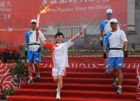 Torchbearer Li Ruiying (2nd L) runs with the torch at the launching ceremony of the Beijing 2008 Olympic Games torch relay in Anyang, central China's Henan Province, July 28, 2008.
