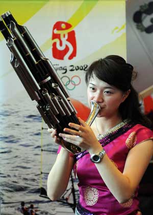 An actress performs with Sheng, a Chinese reed pipe wind instrument, at the Qingdao Olympic village in Qingdao, the co-host city for sailing events of the Beijing 2008 Olympic Games, in east China's Shandong Province. 