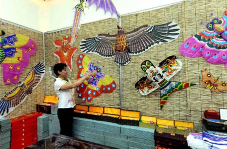 A working member arranges kites at the folk customs culture exhibition at the Qingdao Olympic village in Qingdao, the co-host city for sailing events of the Beijing 2008 Olympic Games, in east China's Shandong Province, July 27, 2008.