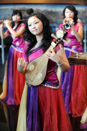 Actresses perform with traditional Chinese musical instruments at the Qingdao Olympic village in Qingdao, the co-host city for sailing events of the Beijing 2008 Olympic Games, in east China's Shandong Province, July 27, 2008.