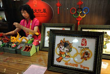 A handicraft artist works at the folk customs culture exhibition in the Qingdao Olympic village in Qingdao, the co-host city for sailing events of the Beijing 2008 Olympic Games, in east China's Shandong Province, July 27, 2008.