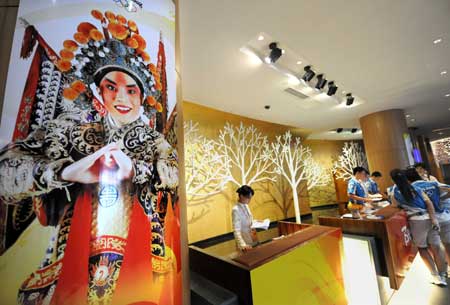 The photo taken on July 27, 2008 shows the Olympic official poster with the figure of a Peking Opera actor at the reception desk of the Qingdao Olympic village in Qingdao, the co-host city for sailing events of the Beijing 2008 Olympic Games, in east China's Shandong Province, July 27, 2008. 