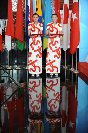 The ceremony girls dressed in cheongsam printed with Chinese seals stand at the Qingdao Olympic village in Qingdao, the co-host city for sailing events of the Beijing 2008 Olympic Games, in east China's Shandong Province, July 27, 2008. 