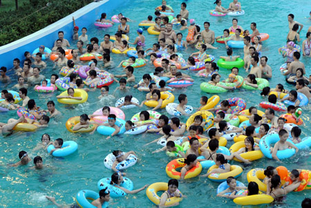 People try to cool off at a crowded swimming pool at the Tianmu lake amusement park in Liyang, East China's Jiangsu province, on the evening of July 25, 2008.