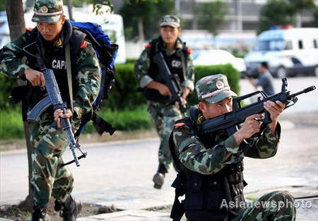 Armed policemen take positions in an anti-terrorist drill in Huaibei of Anhui province on July 27, 2008. 