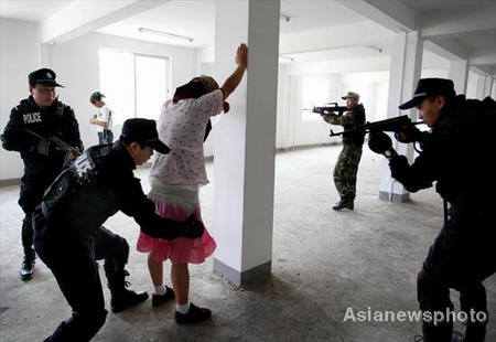 Policemen check out a suspect during an anti-terrorist drill in Huaibei of Anhui province on July 27, 2008.