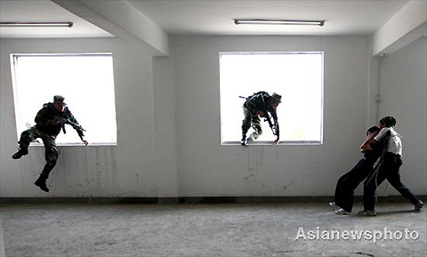 Special forces break into the window to rescue the hostage during an anti-terrorist drill in Huaibei of Anhui province on July 27, 2008. 