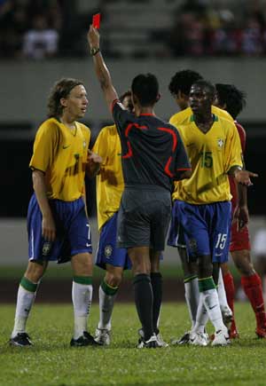 Brazil's Olympic soccer players (L-R) Lucas, Rafinha and Ramires react as referee Abdul Malik Bashir shows the red card to teammate Alex Silva (not pictured) during their friendly soccer match against Singapore in Singapore July 28, 2008.