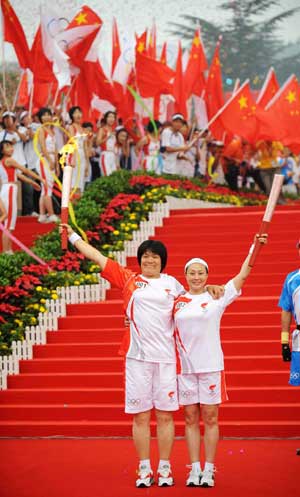 Torchbearer Li Sumei (L) poses with the next torchbearer Yuan Shumei during the Beijing 2008 Olympic Games torch relay in Shijiazhuang, capital of north China's Hebei Province, July 29, 2008. 