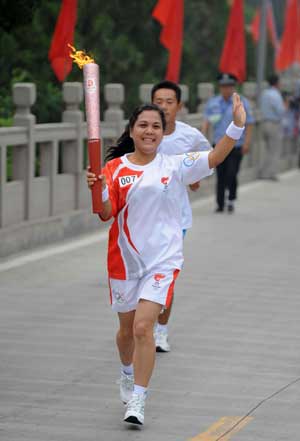 Torchbearer Liu Yanhong holds up the torch during the Beijing 2008 Olympic Games torch relay in Shijiazhuang, capital of north China's Hebei Province, July 29, 2008. 