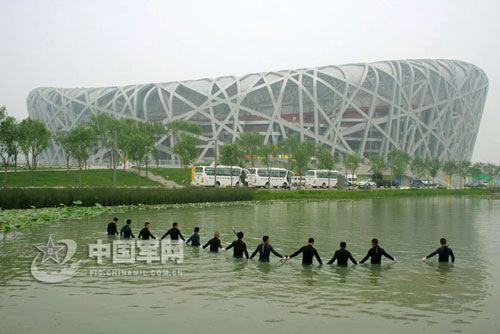 July 25, hand-in-hand combat divers from the People's Liberation Army South China Sea Fleet comb the artificial lake around the Bird's Nest where the opening and closing ceremonies and athletics events of the upcoming Olympic Games will be held.
