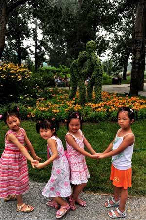Girls pose for photos as they visit an international flowers exhibition in Beijing Botanical Garden in Beijing, capital of China, July 27, 2008. With an area of 60,000 square meters, the exhibition showcased more than one million of rarity flowers and trees of over 1,000 species from 205 countries and regions in the five continents. 