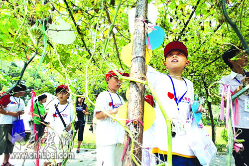 Children hang love notes onto trees in the botanical garden in Wuhan during a summer camp on July 27, 2008.