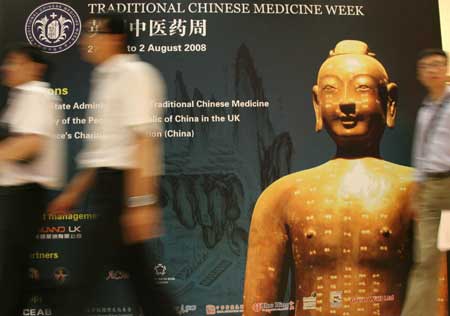 Visitors walk past a poster during the Traditional Chinese Medicine Week at the Royal Society of Medicine in London, Britain, July 28, 2008. The one-week event, starting from July 27, is aimed at promoting greater understanding and cooperation in medicine between China and the UK. 