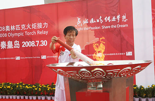 Last torchbearer Wang Santang lights the cauldron during the torch relay in Qinhuangdao, Hebei province on July 30, 2008.