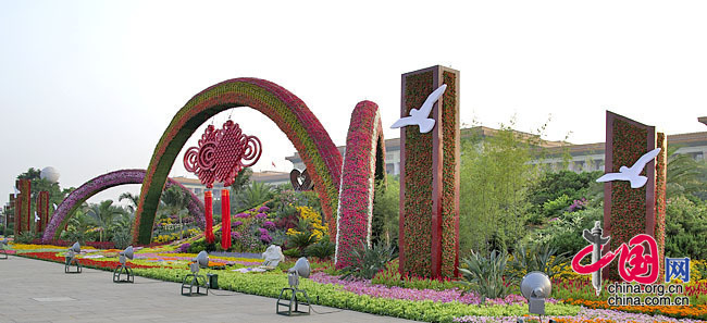 In the western corner of Tian&apos;anmen Square, the flower terrace themed &apos;A Harmonious Society Brought about by the Reform and Opening-up&apos; is decorated by the rainbow gates and the Chinese knots and a colorful brook flowing down from the flower mountain. The brook has the pattern of 56 flowers and joined hands symbolizing the unity of 56 nationalities of China. 