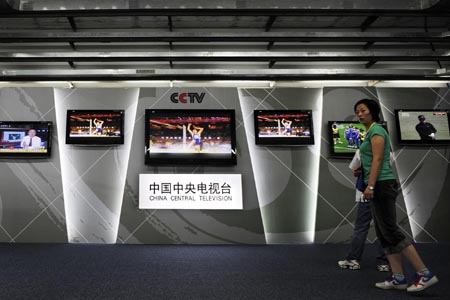 Two staff members pass by the display screens broadcasting high definition signals of CCTV (China Central Television) in the International Broadcast Center (IBC) in Beijing, China, July 29, 2008. It’s said that high definition signals will be first-ever used for TV relays for all 28 events of Beijing 2008 Olympic Games. BOB will produce live TV signals of 5,400 hours for right-holding broadcasters and it’s estimated that more than four billion viewers will enjoy the olympic competition through TV broadcasts in 2008. (Xinhua/Li Ziheng)