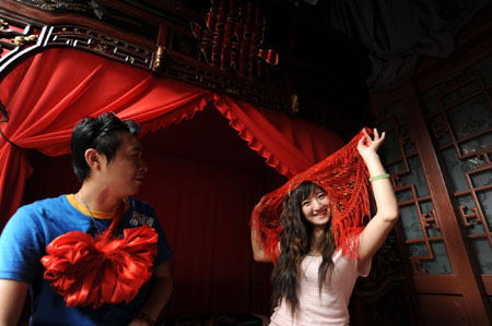 A couple demonstrate Chinese traditional wedding custom in the guest room of the Olympic homestay dwelling at No. 39 of the South Guanfang Hutong in Beijing, China, July 29, 2008. 