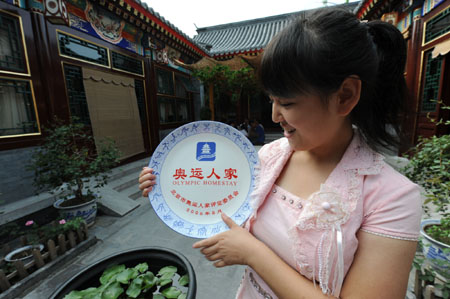 Tour guide Li Fenxia shows the porcelain doorplate of the Olympic homestay dwelling at No. 39 of the South Guanfang Hutong in Beijing, China, July 29, 2008. 