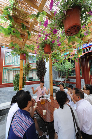 Tour guide Li Fenxia (back) introduces the history of the Olympic homestay dwelling at No. 39 of the South Guangfang Hutong in Beijing, China, July 29, 2008. 