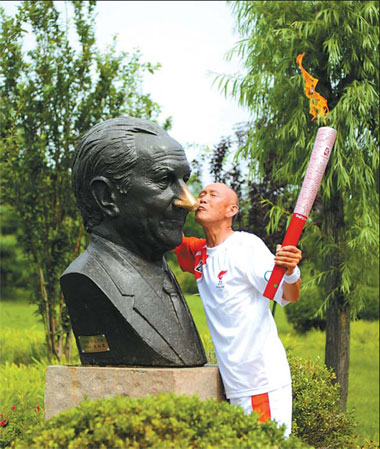 Ji Shaolin plants a kiss on the bronze statue of Juan Antonio Samaranch during yesterday's relay in Qinhuangdao. 