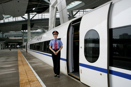 A stewardess stands at the entrance to a Beijing-Tianjin high-speed train on its test run July 12, 2008. The new 350 kph train shortens the journey between the two cities to just 30 minutes. The Beijing-Tianjin high-speed railway will open on August 1, 2008.