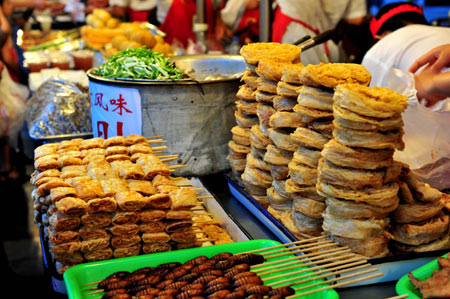 Photo taken on July 26, 2008 shows a snack booth in a snack street of Beijing, capital of China. In the past, the popular Beijing snacks used to be hawked at temple fairs or roadside bazaars. Along with the change of times, traditional Beijing snack bars have emerged in streets and lanes of the city. There are also some snack streets with business of traditional Beijing snacks and other flavor snacks from around China that favor lots of local residents and tourists. 