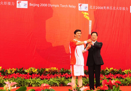 Zhang Gaoli (R), secretary of the Tianjin Municipal Committee of the Communist Party of China (CPC), hands over the torch to the first torchbearer Kong Xiangrui during the 2008 Beijing Olympic Games torch relay in north China's Olympics co-host city Tianjin, August 1, 2008. [Xinhua]