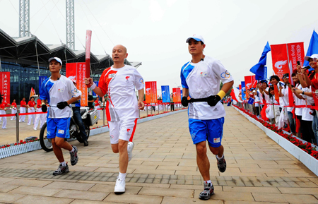 Torchbearer Ge You runs with the torch during the 2008 Beijing Olympic Games torch relay in north China's Olympics co-host city Tianjin, August 1, 2008. [Xinhua]