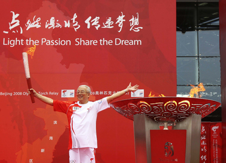 The last torchbearer Huang Qixing greets the audience after lighting the cauldron during the 2008 Beijing Olympic Games torch relay in north China's Olympics co-host city Tianjin, August 1, 2008. [Xinhua]