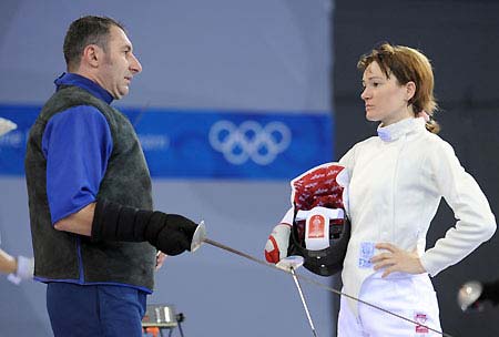 A foil fencer from the Roumanian Olympic team gets instruction from her coach inside the Fencing Hall of National Convention Center, in Beijing July 30, 2008.