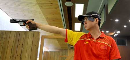 Chinese rapid fire pistol shooter Zhang Penghui practises during a training at the Beijing Shooting Range in Beijing, capital of China, July 31, 2008. 