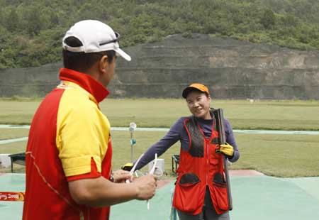 Chinese shooter Liu Yingzi (R) talks with her coach during a training at the Beijing Shooting Range in Beijing, capital of China, July 31, 2008.