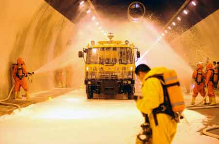 Firefighters take part in a fire drill at a tunnel on the highway linking Hefei and Mount Huangshan in east China's Anhui Province, Aug. 3, 2008. The exercise aims to raising the response level of traffic accidents which might cause injuries, leakage of hazardous materials, fire and explosion.